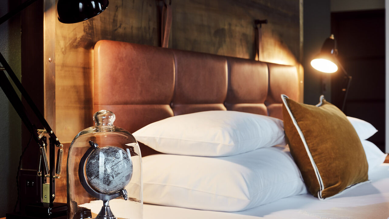Gemütliches Bett im L-Loft von der Seite mit Nachttischlampe