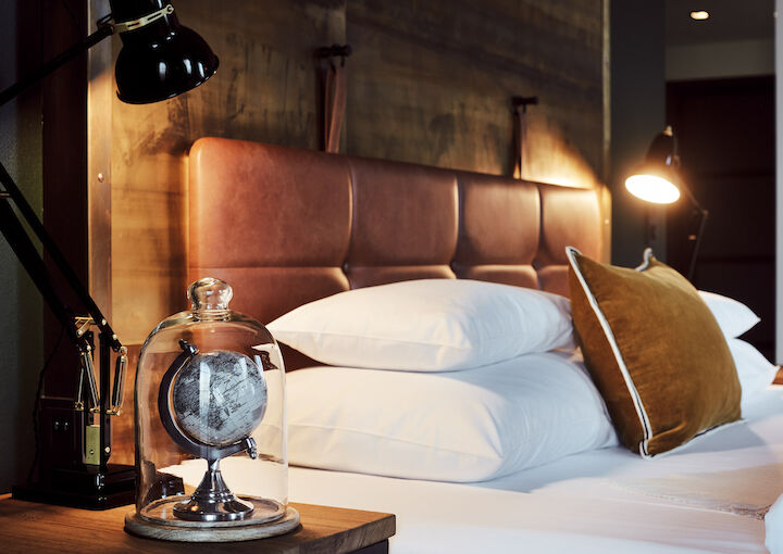 Gemütliches Bett im L-Loft von der Seite mit Nachttischlampe