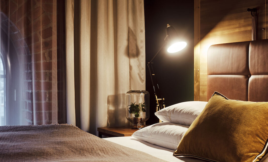 Gemütliches Bett im S-Loft von der Seite mit Nachttischlampe