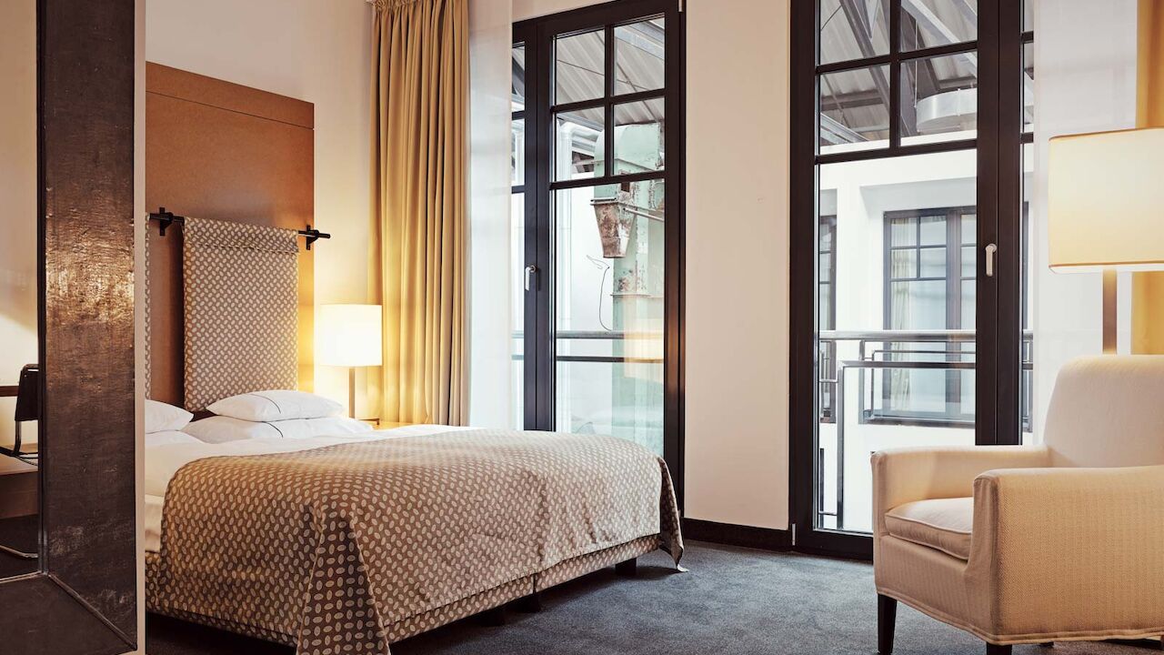 Bett und Sessel im S-Loft mit Blick in die Hotellobby