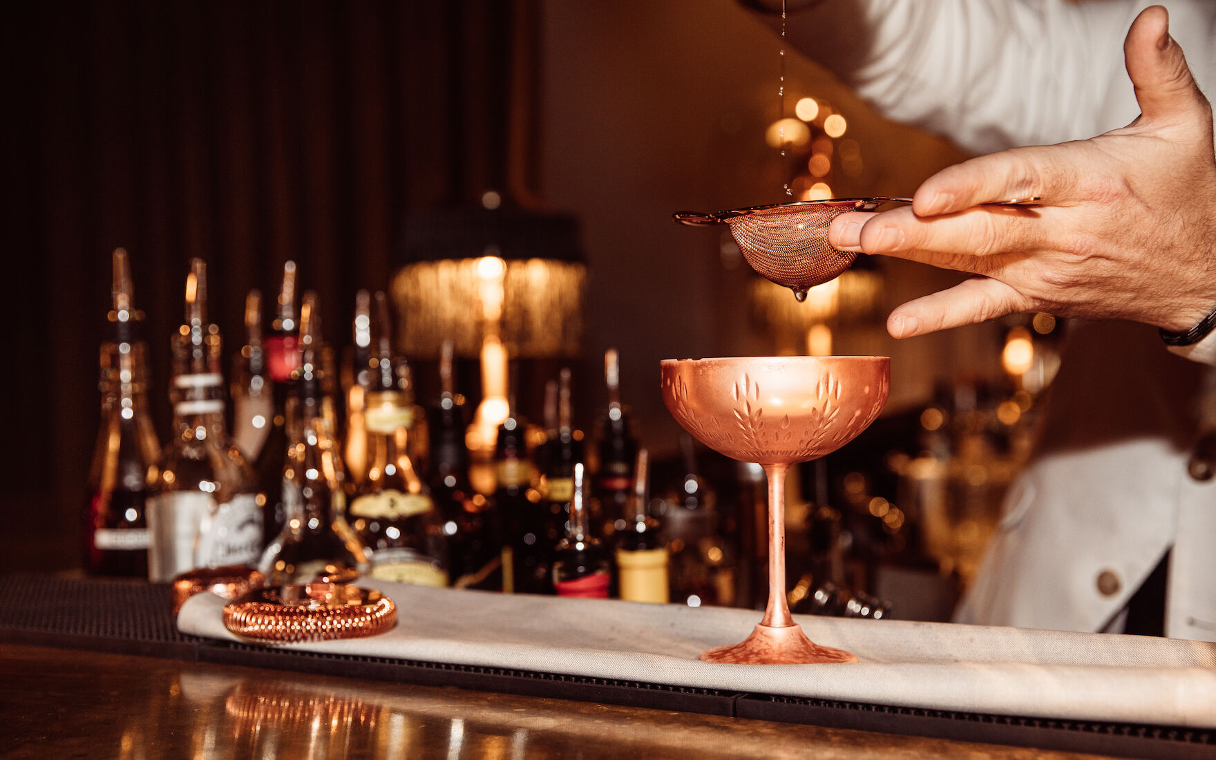 Barkeeper gießt Drink durch Strainer in der Mangold Bar im Gastwerk Hotel