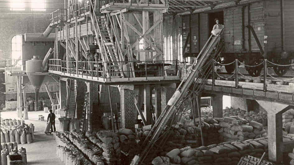 Das frühere Mahlwerk mit Futtersäcken und Arbeitern im Gastwerk vor dem Umbau