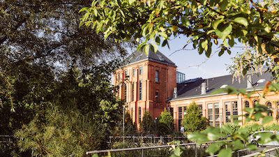 Gastwerk Hotel von Bäumen und Pflanzen eingerahmt, Außenansicht