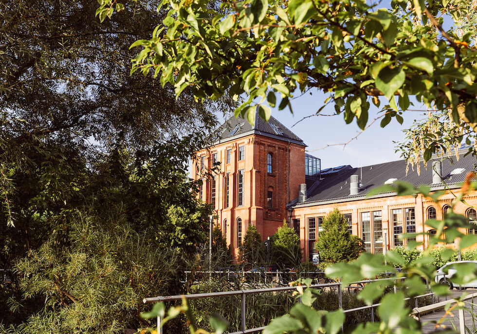 Gastwerk Hotel von Bäumen und Pflanzen eingerahmt, Außenansicht