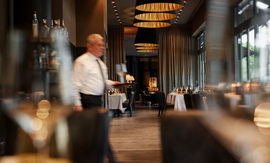 The George Hotel Hamburg Restaurant Dacaio 05 Waiter serving chilled white wine at Restaurant DaCaio