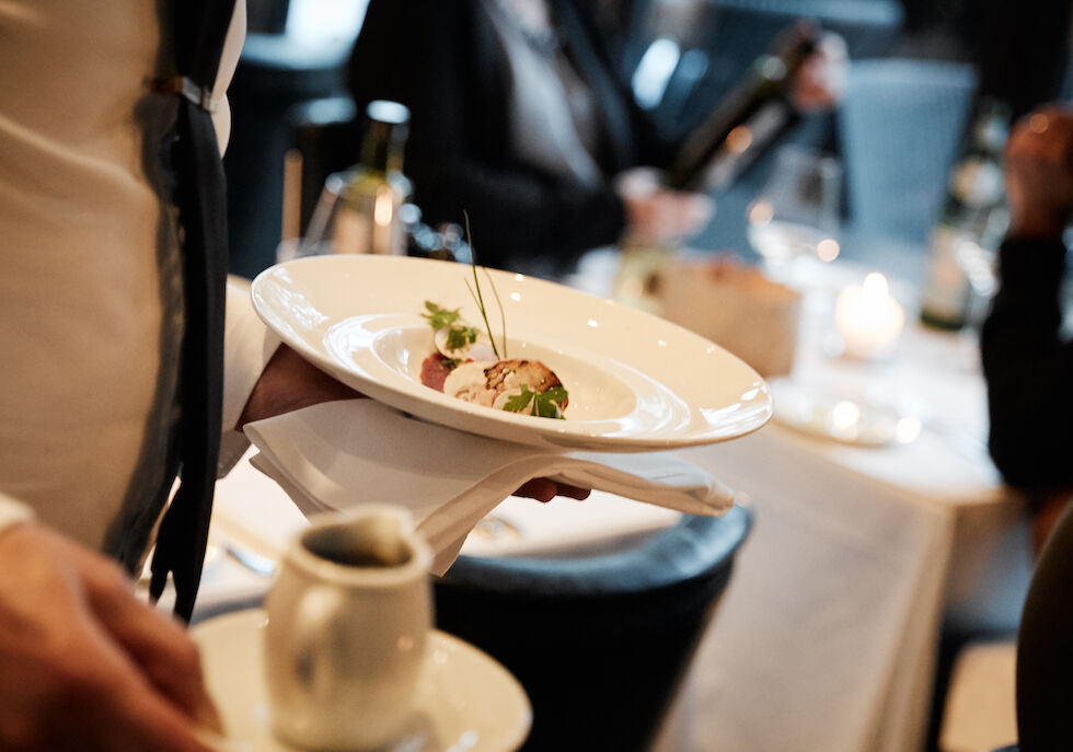 Beautifully arranged dish served by waiter with broth on side