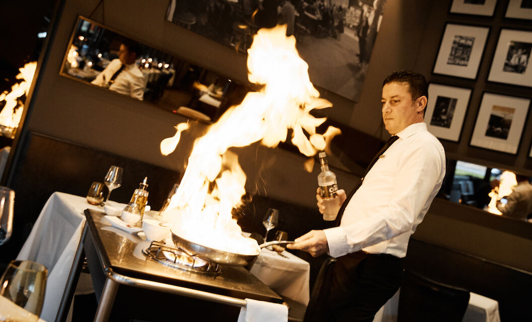 The George Hotel Hamburg Restaurant Dacaio 13 People Scampi being flambéed by waiter at DaCaio restaurant