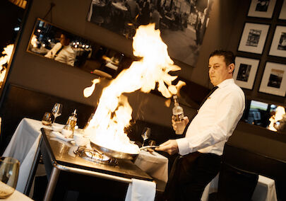 The George Hotel Hamburg Restaurant Dacaio 13 People Scampi being flambéed by waiter at DaCaio restaurant