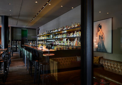 The George Hotel Hamburg Bar Dacaio 05 Long bar with fully stocked shelf of various spirits in view