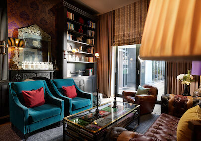 Buchwerk Hamburg Veranstaltungsbereich Library 01 Library mit zwei blauen Sesseln, zwei Ledersesseln und Chesterfield Couch