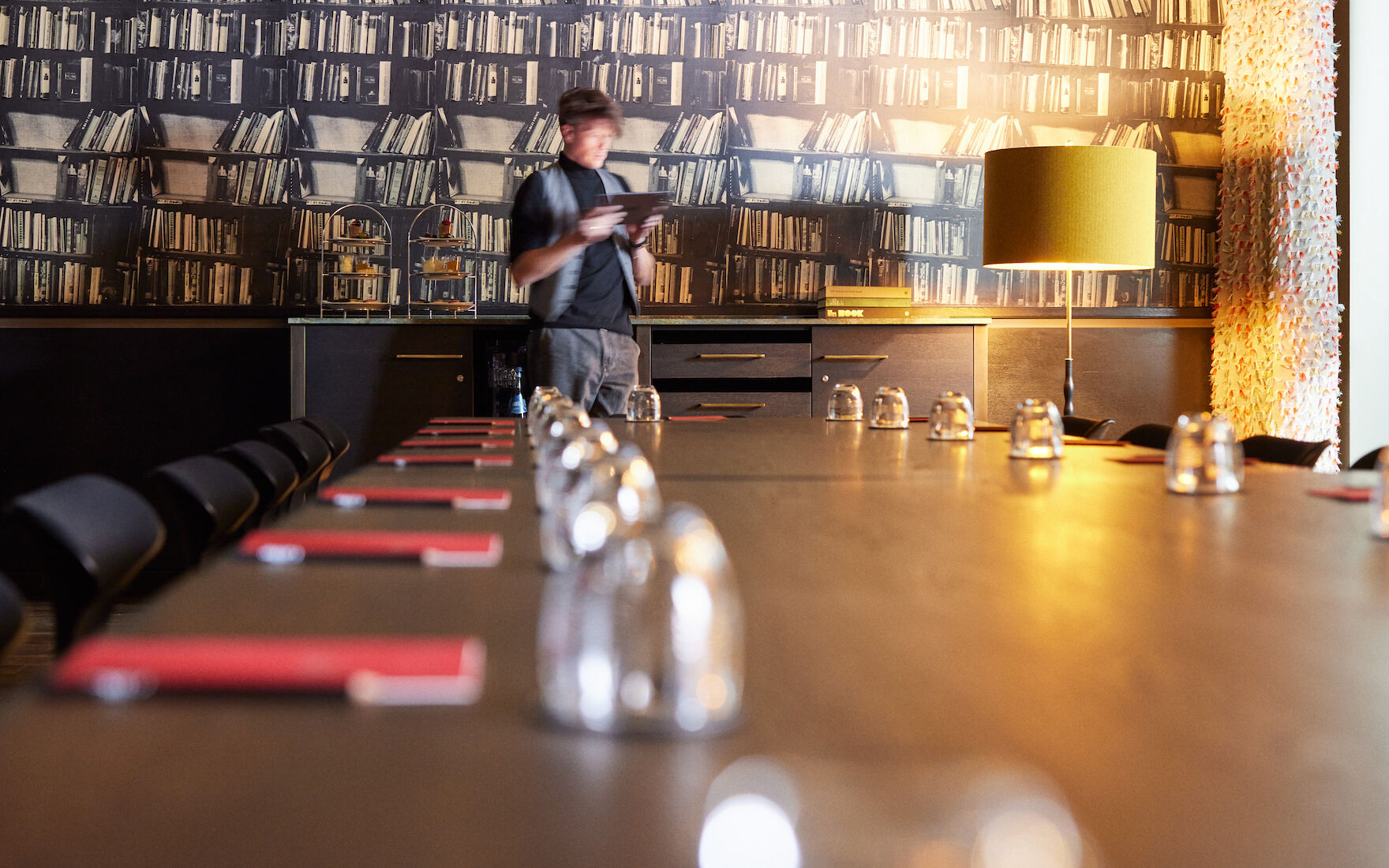 View along large table in Clubroom XL, man with tablet in background