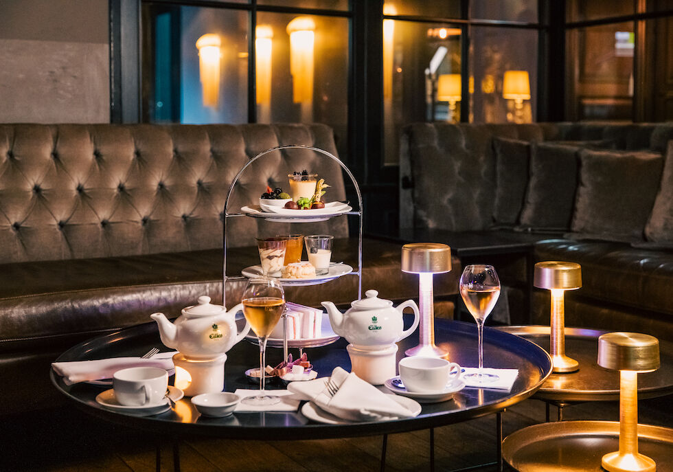 Afternoon tea with tiered stand, cakes, sandwiches and coffee pots
