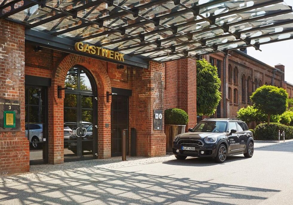 Eingangsbereich des Gastwerk Hotels Hamburg mit parkendem Auto davor
