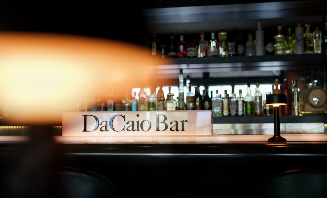 The George Hotel Hamburg Bar Dacaio 01 Lamp foreground with spirits rack and DaCaio Bar logo behind