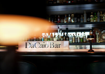 The George Hotel Hamburg Bar Dacaio 01 Lamp foreground with spirits rack and DaCaio Bar logo behind