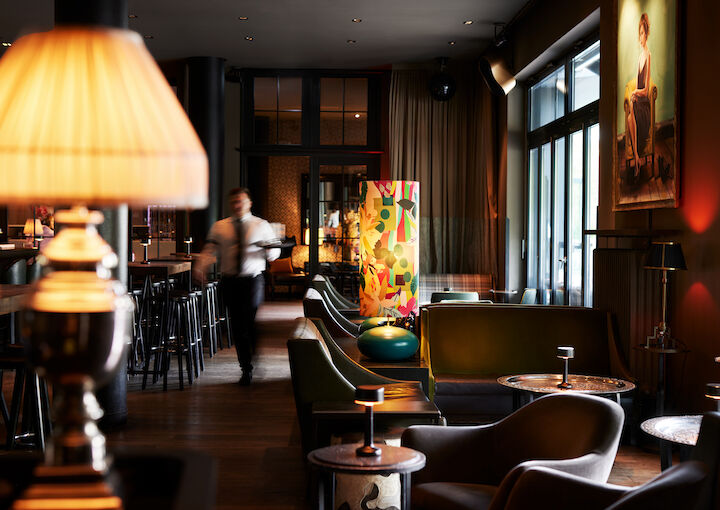 Cosy seating areas in DaCaio bar with waiter walking by