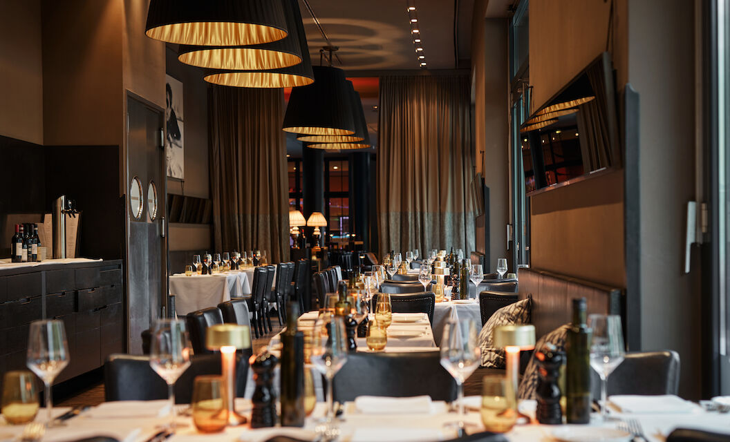 The George Hotel Hamburg Restaurant Dacaio 04 Close-up of beautifully set dinner tables in soft light