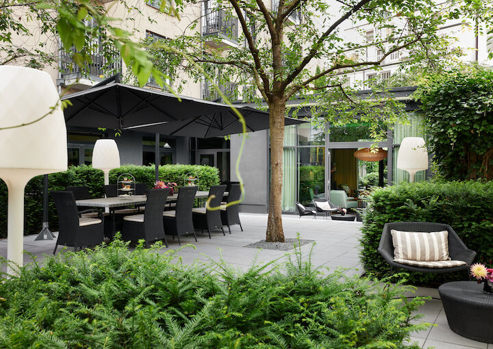 Garden table shaded by parasols and cherry trees