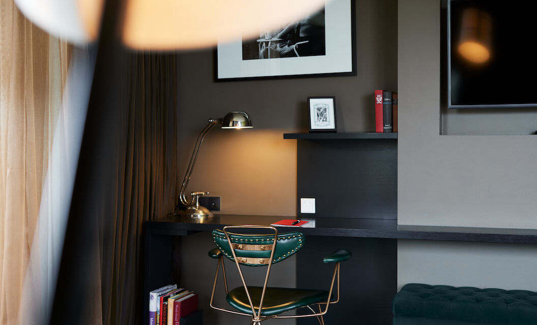 Desk with a green chair and a silver lamp