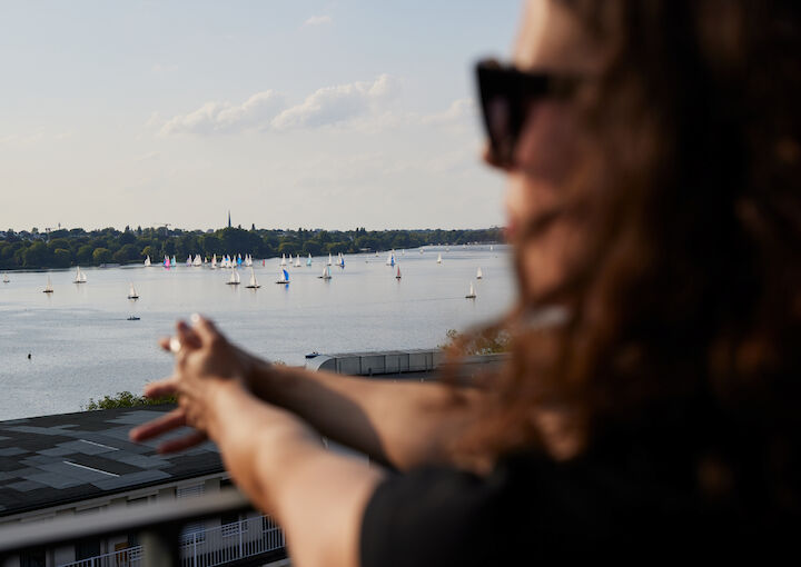 Woman looking out over Alster and watching sailboats glide