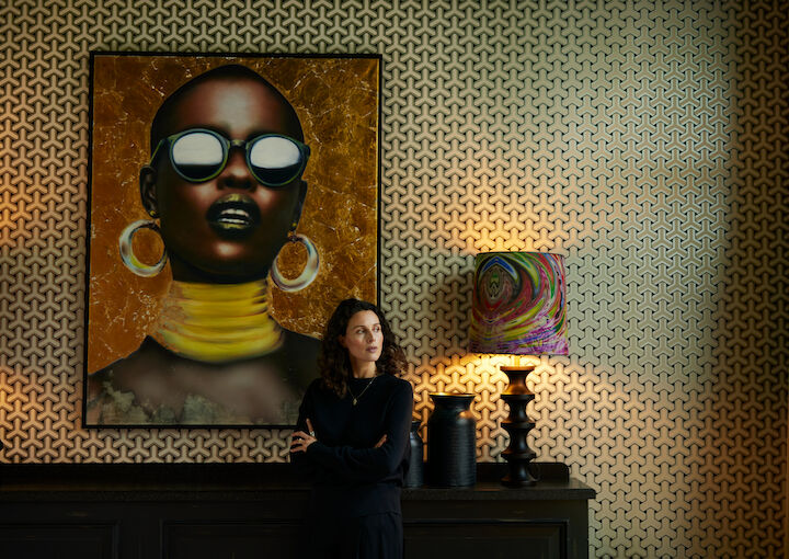 Women standing in the Library in front of a large artwork