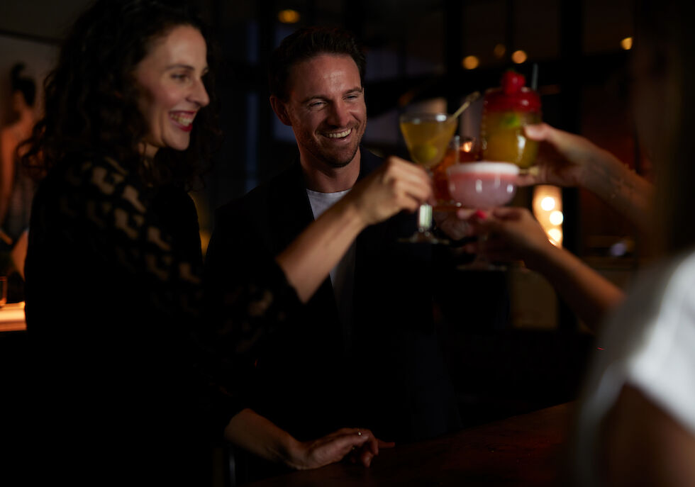 People toast with cocktails in a friendly gathering