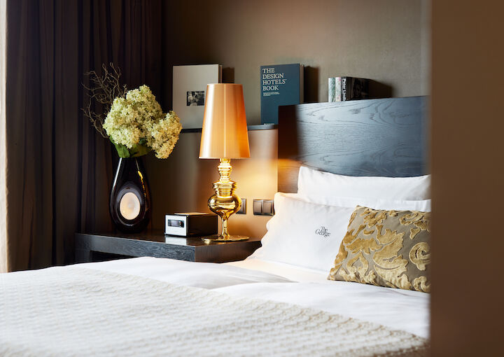 Side view of headboard with golden lamp and books in the background