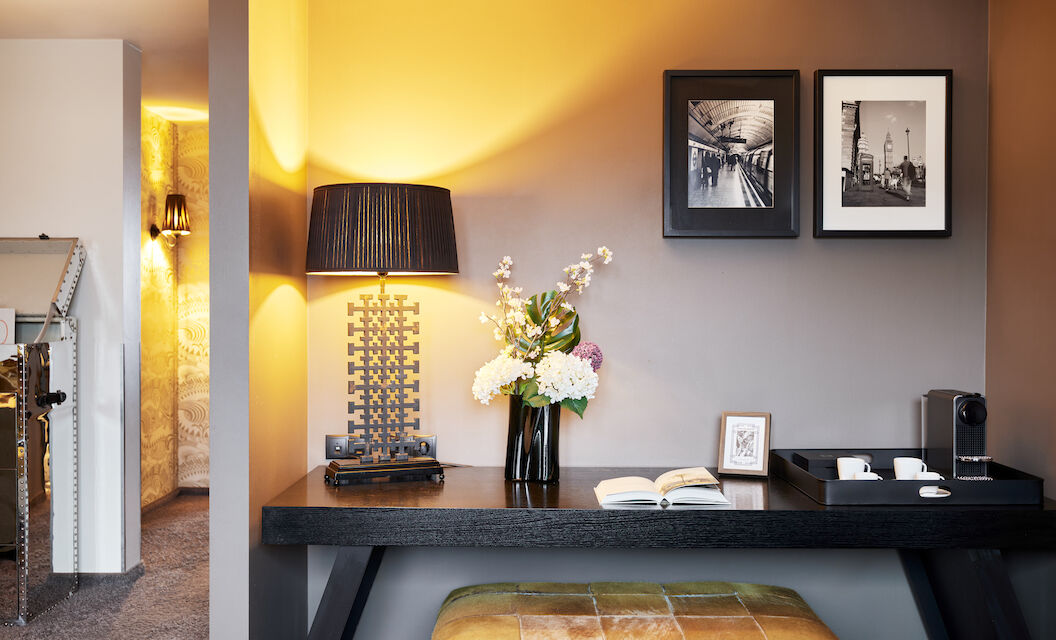 Desk with floor lamp, book, decor and two framed pictures on wall