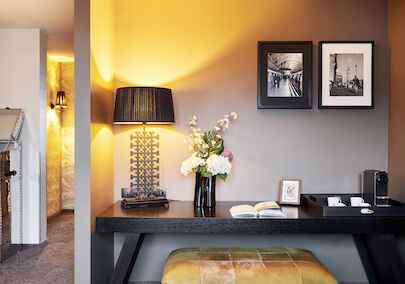 Desk with floor lamp, book, decor and two framed pictures on wall