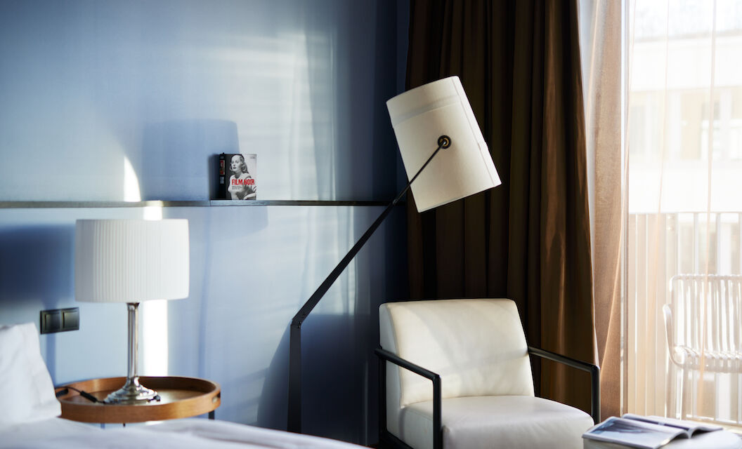 White armchair next to floor lamp against blue wall in M-Room