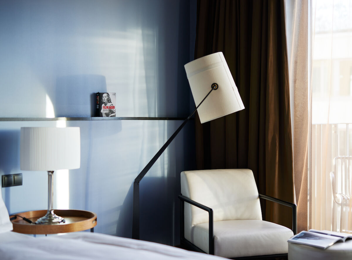 White armchair next to floor lamp against blue wall in M-Room