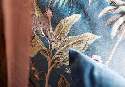 Close-up of a cushion featuring plants and monkeys