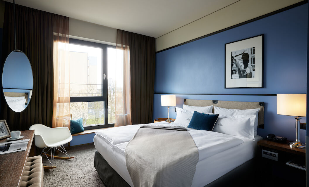 Kingsize bed in front of blue wall with wall decor in S-Room.