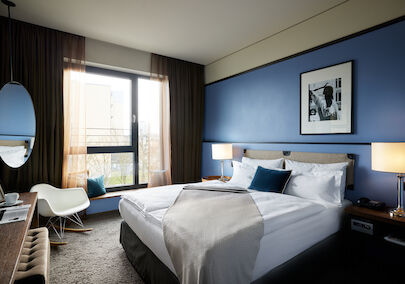 Kingsize bed in front of blue wall with wall decor in S-Room.