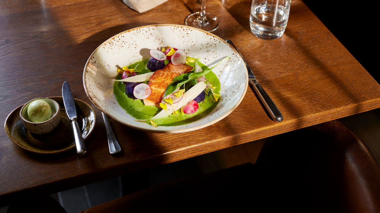 Gebratener Lachs mit regionalem Gemüse im Restaurant Mangold
