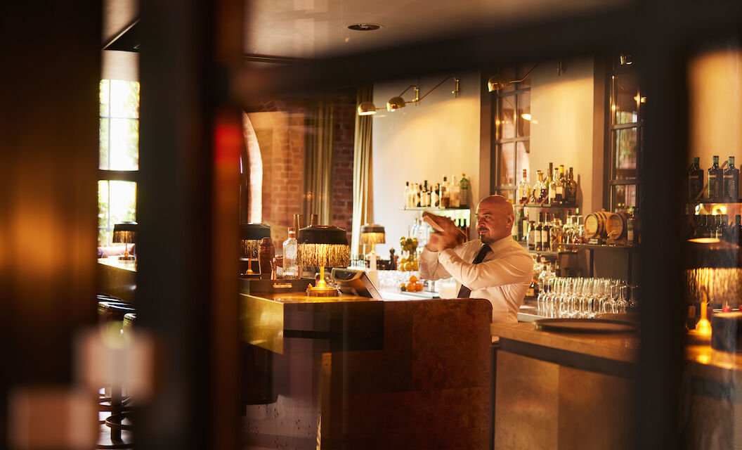 Barkeeper mixt hinter dem Tresen der Bar Mangold einen Drink.