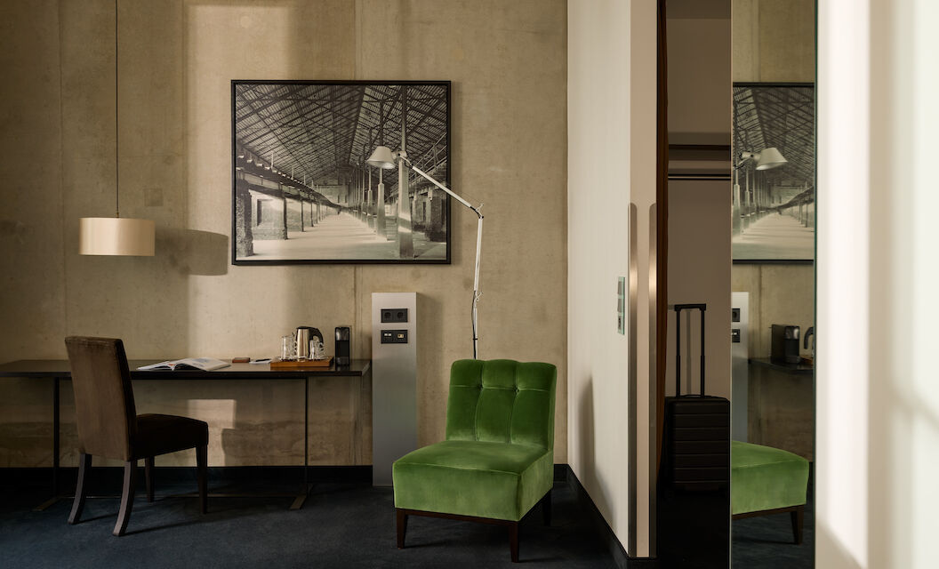 Zimmer M Loft im Gastwerk Hotel Hamburg mit grünem Sessel neben dem Schreibtisch