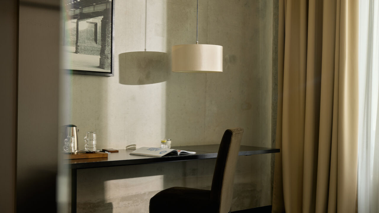 Gastwerk Hotel Hamburg Zimmer M Loft 016 05 M-Loft im Gastwerk Hotel mit Stuhl am Schreibtisch, Bild und Lampe an der Wand