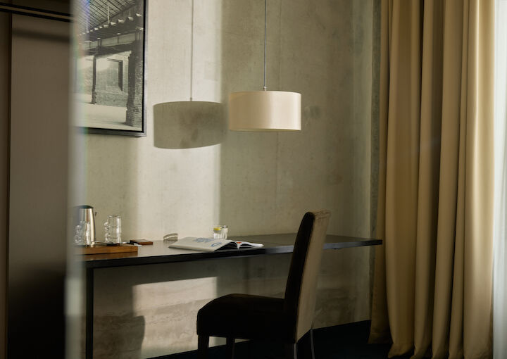 M-Loft im Gastwerk Hotel mit Stuhl am Schreibtisch, Bild und Lampe an der Wand
