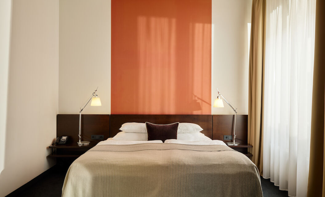 Zimmer M Loft im Gastwerk Hotel Hamburg mit frontalem Blick auf das Bett und zwei Nachttische