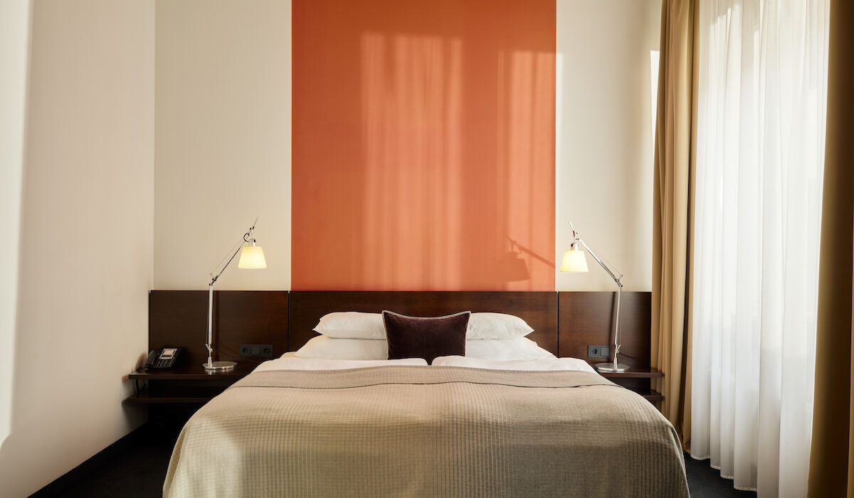 Zimmer M Loft im Gastwerk Hotel Hamburg mit frontalem Blick auf das Bett und zwei Nachttische