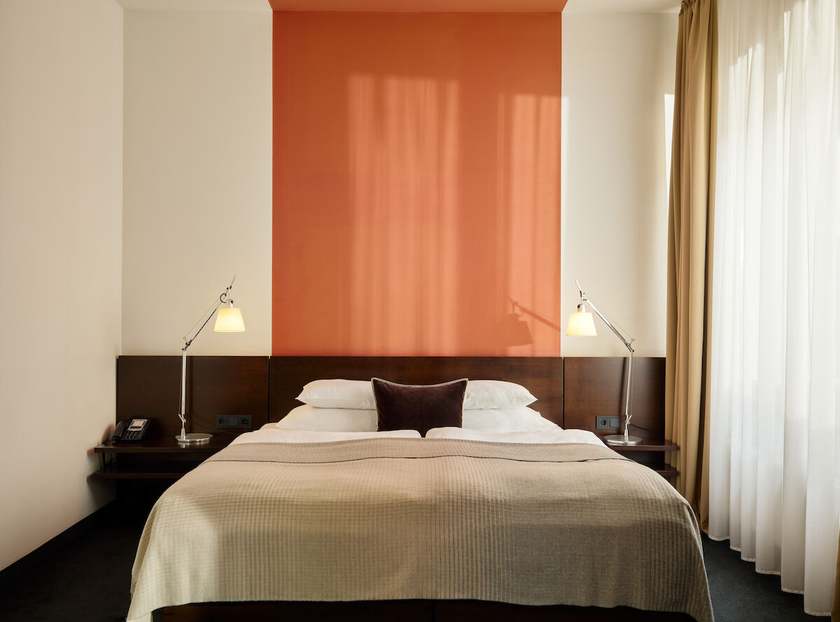 Zimmer M Loft im Gastwerk Hotel Hamburg mit frontalem Blick auf das Bett und zwei Nachttische