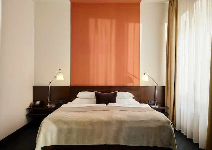 Zimmer M Loft im Gastwerk Hotel Hamburg mit frontalem Blick auf das Bett und zwei Nachttische
