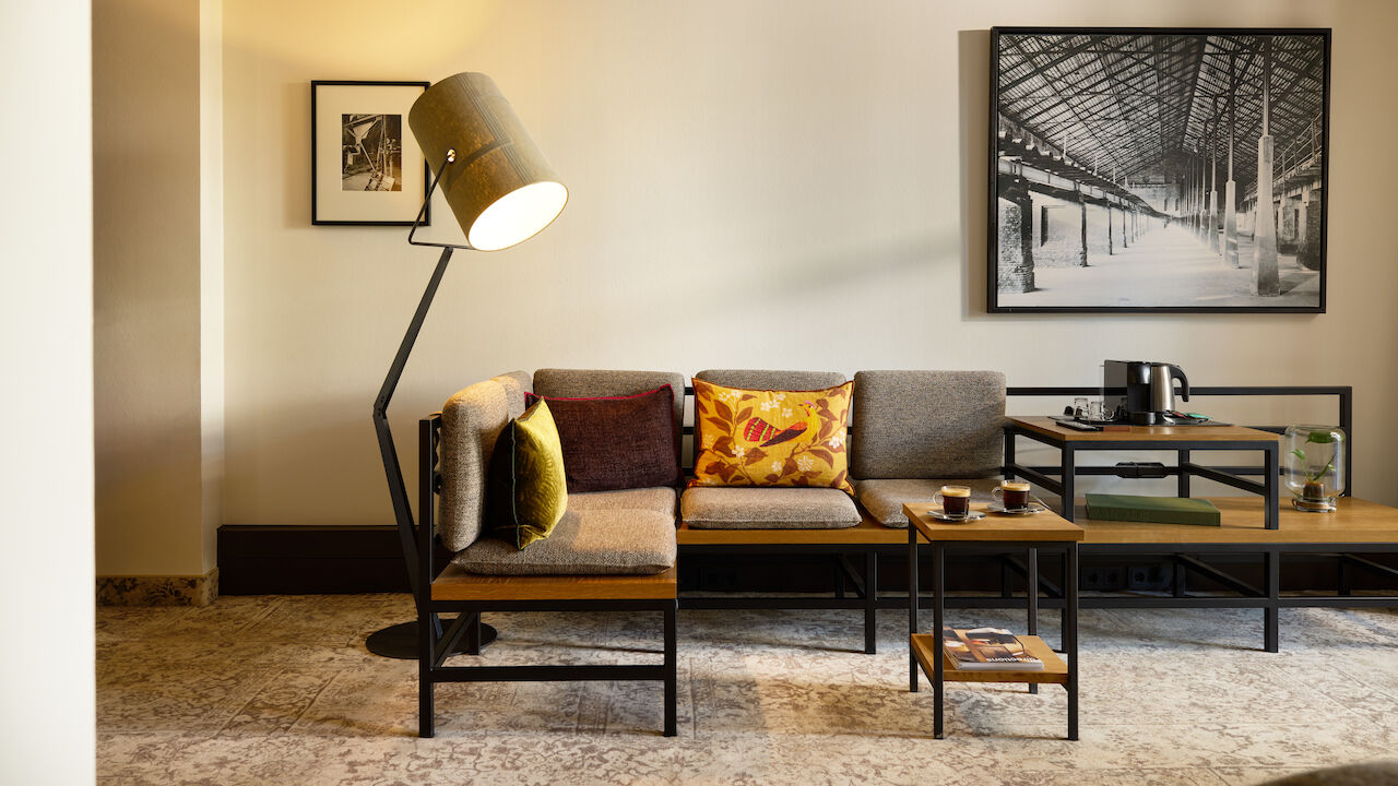 S Loft Atrium im Gastwerk Hotel Hamburg mit Sofaecke und großer Stehlampe