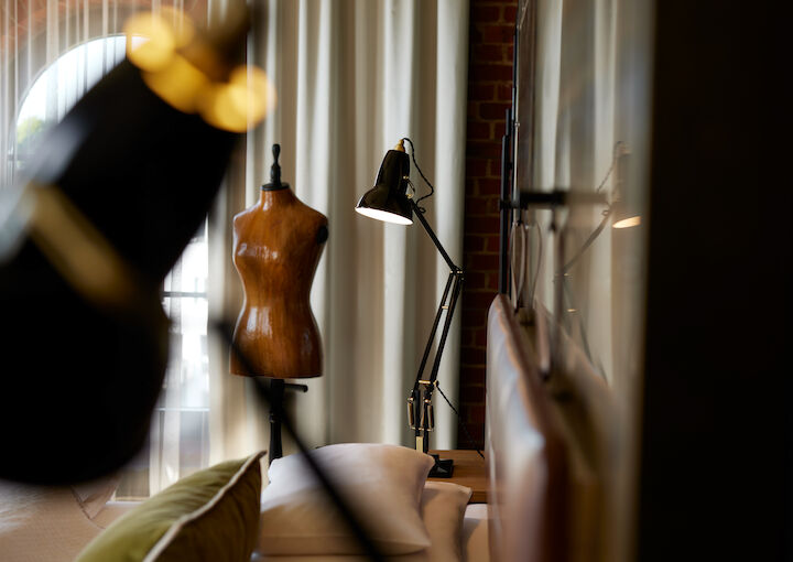 L Loft mit schwarzen Lampen und Schneiderpuppe im Hintergrund