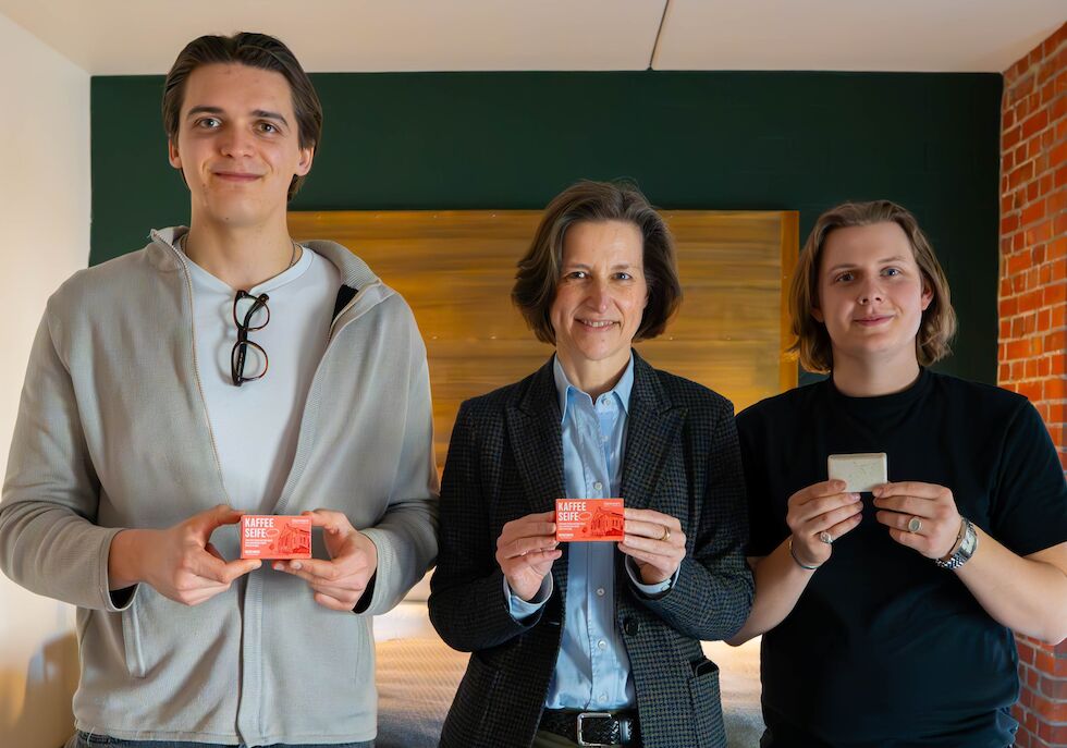 Gruppenbild von drei Personen, die Kaffeeseife in den Händen halten