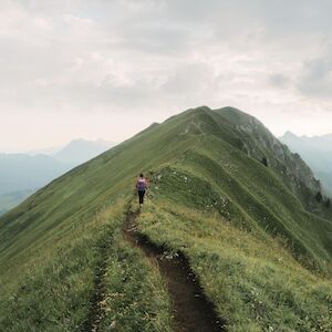 Großaufnahme eines Bergpanoramas mit wandernder Person im Bild